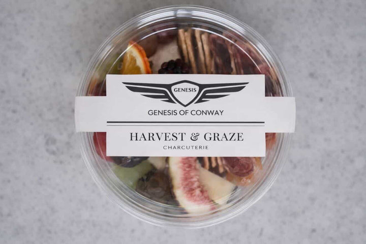 Container of charcuterie with a label on a gray background
